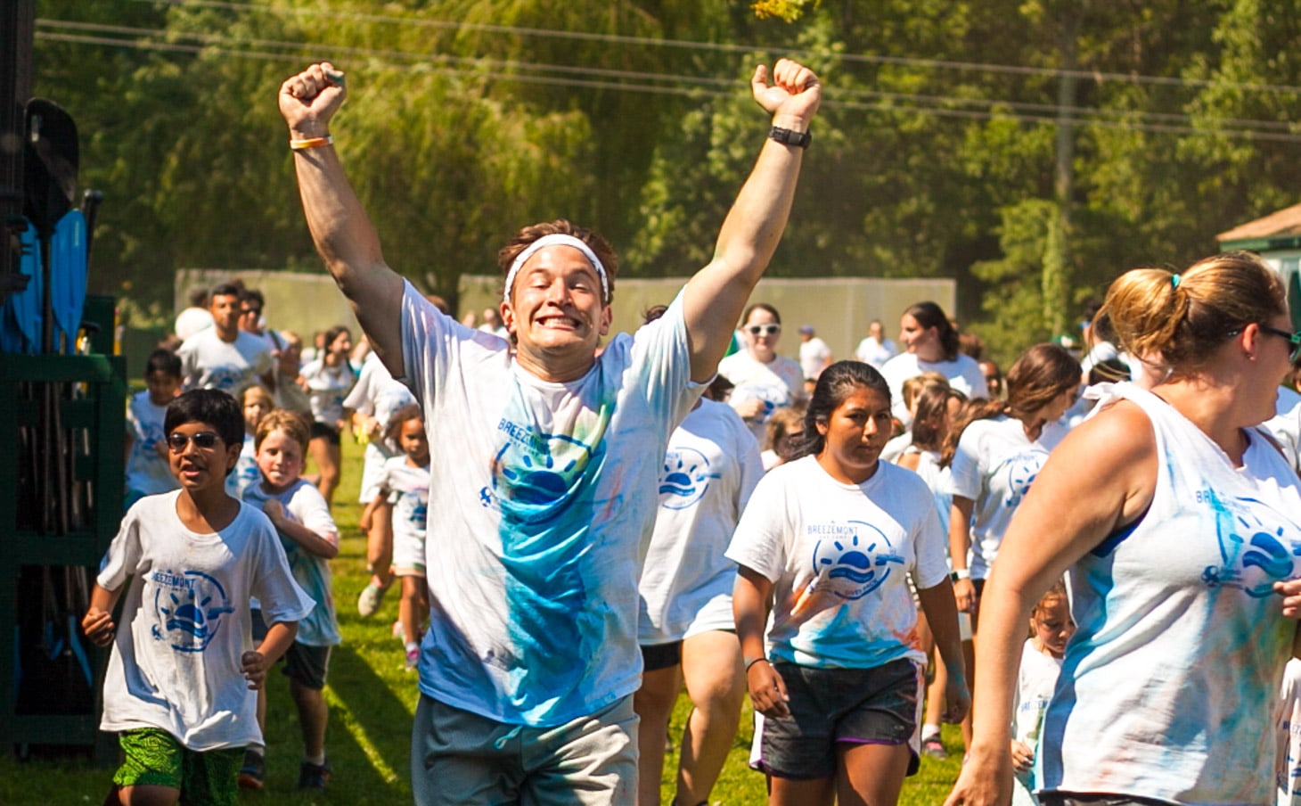 A camper running triumphantly with his hands in the air.