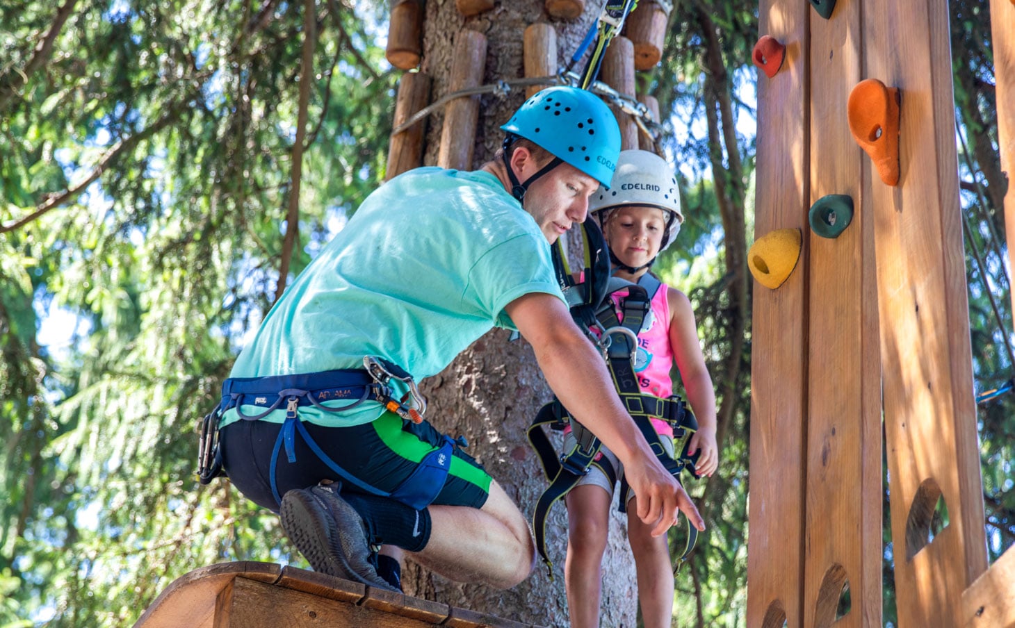 A camper and a staff member getting ready to zip line across campus.