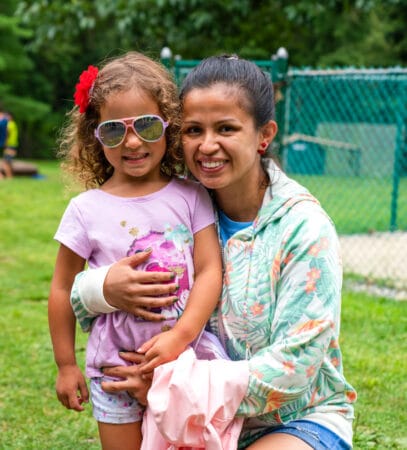 A mother and daughter smiling at camp.