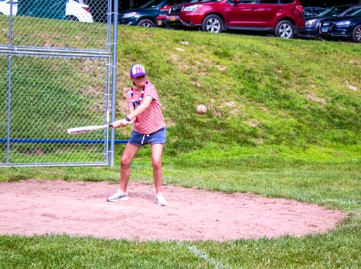 Campers playing softball on the baseball fields on campus.