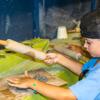 A camper shaping an object during pottery activities.