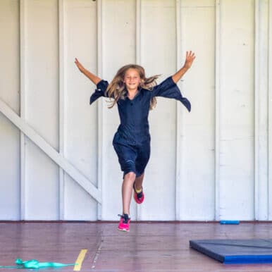 A camper dancing and jumping in the air.